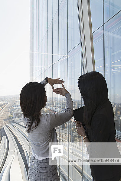 Geschäftsfrauen im Gespräch am Fenster des Hochhausbüros