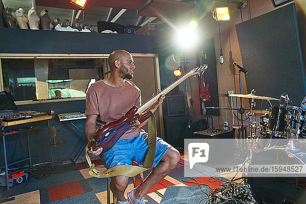 Männlicher Musiker spielt Gitarre im Aufnahmestudio