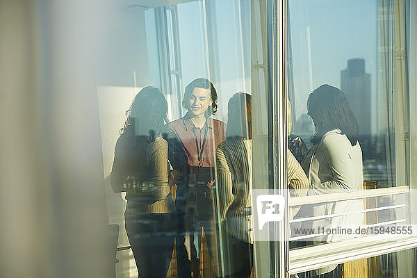 Geschäftsleute im sonnigen Bürofenster im Gespräch