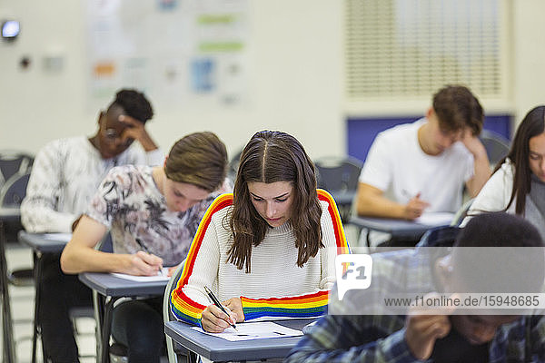 Fokussierte Gymnasiastin nimmt Prüfung am Schreibtisch am Computer ab