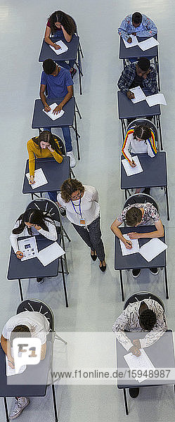 Gymnasiallehrer beaufsichtigt Schüler  die Prüfungen am Schreibtisch ablegen