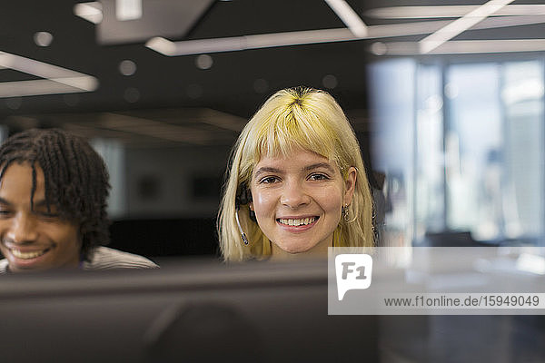 Porträt einer selbstbewusst lächelnden Geschäftsfrau mit Headset im Büro