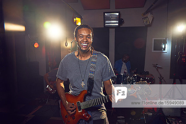 Porträt eines selbstbewussten männlichen Musikers der im Aufnahmestudio Gitarre spielt