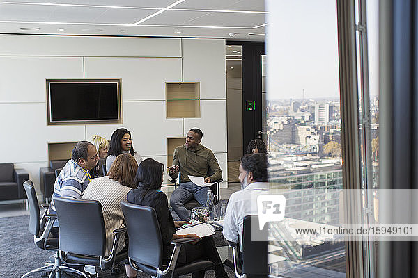 Business people talking in circle in conference room meeting