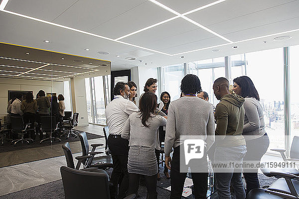 Business people standing in huddle in office