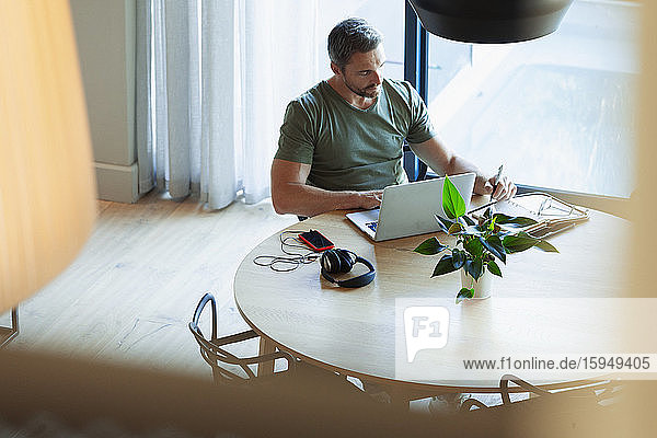 Man using laptop  working from home at dining table
