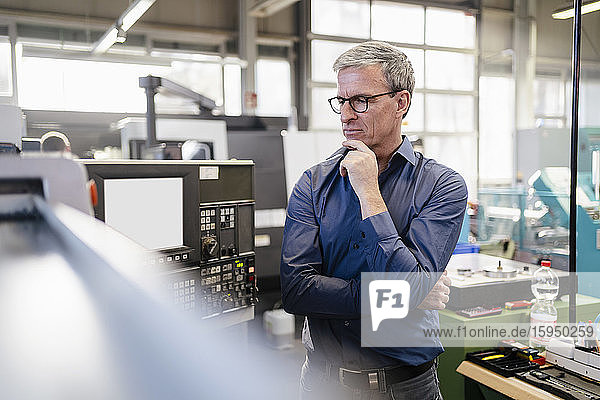 Portrait of mature businessman working in factory