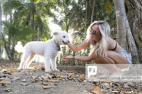 Schöne Frau spielt mit ihrem Hund am Strand  Costa Rica