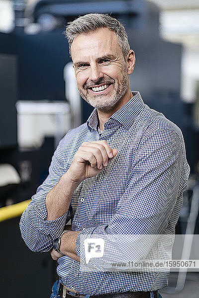 Portrait of a happy businessman in a factory