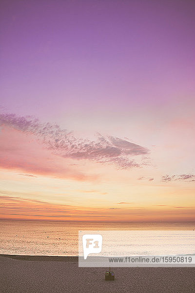 Szenische Ansicht des violetten und orangefarbenen Himmels über dem Meer bei Sonnenaufgang