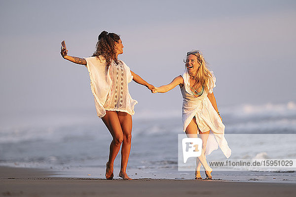 Zwei glückliche Frauen  die am Strand Selbsthilfe betreiben  Costa Rica