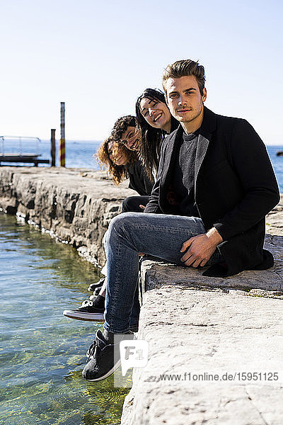 Portrait of four friends sitting at Lake Garda  Italy