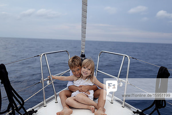 Siblings sitting on boat deck