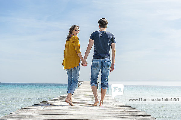 Couple walking hand in hand on jetty  Mallorca  Spain