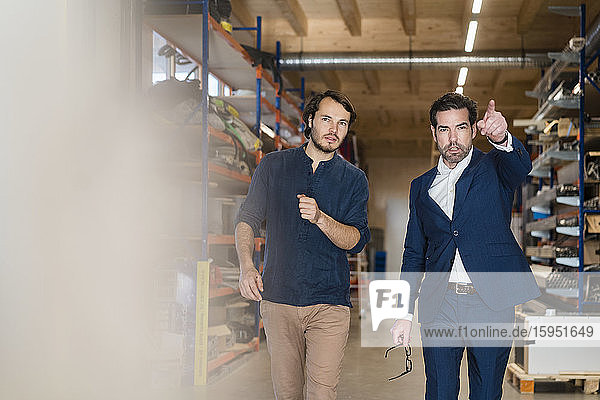 Businessman and employee talking in factory