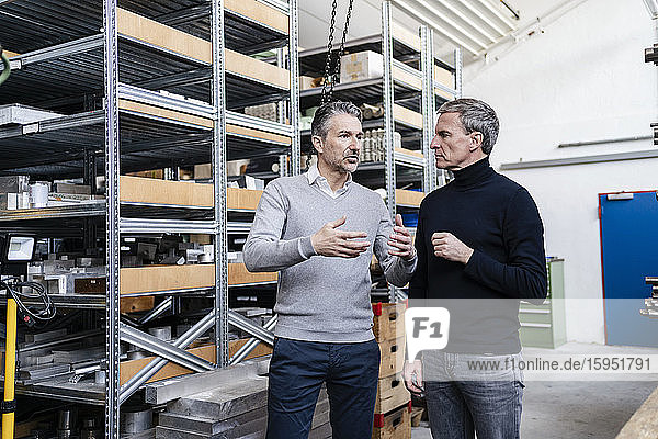 Businessmen in factory  having a meeting  discussing solutions