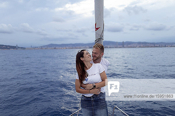 Smiling couple embracing during sailing trip
