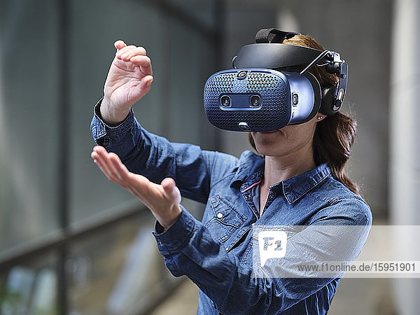 Frau mit VR-Brille und Headset im modernen Büro