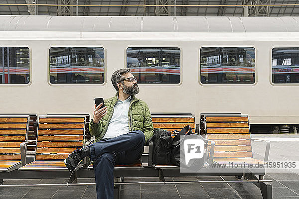 Man sitting on a bench at the train station