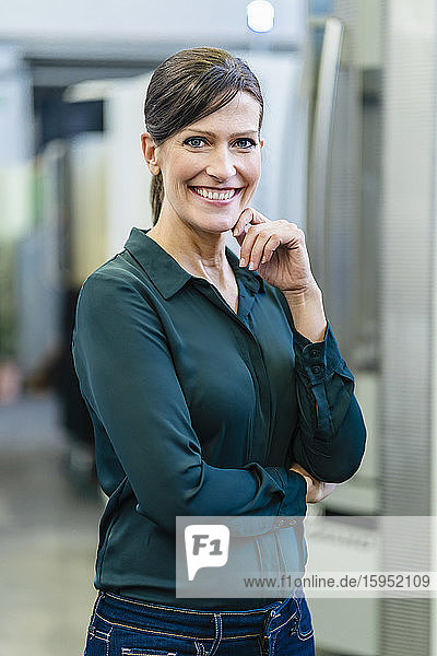 Porträt einer lächelnden Geschäftsfrau in einer Fabrik