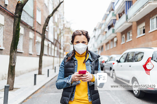 Woman wearing protective mask and using smartphone