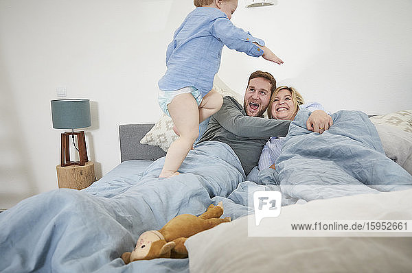Family relaxing and jumping on bed