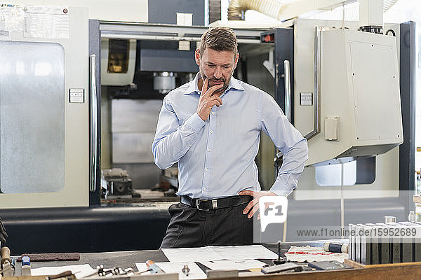 Mature man looking at plan in a factory