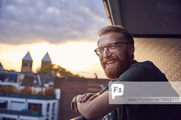 Portrait of relaxed man on balcony looking at distance