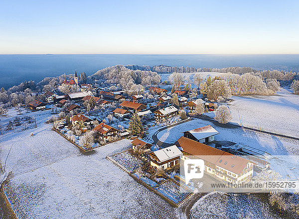 Deutschland  Bayern  Hechenberg  Drohnenansicht eines schneebedeckten Dorfes in der Nebeldämmerung
