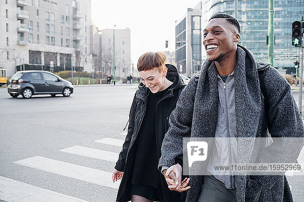 Happy young couple crossing a street in the city  Milan  Italy