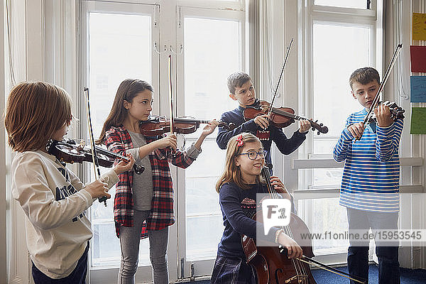Group of children playing violin during a lesson