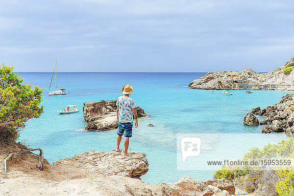 Mann steht auf einer Klippe und schaut aufs Meer  Ibiza  Spanien