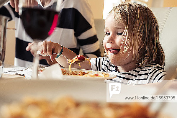Porträt eines glücklichen kleinen Mädchens  das Spaghetti isst