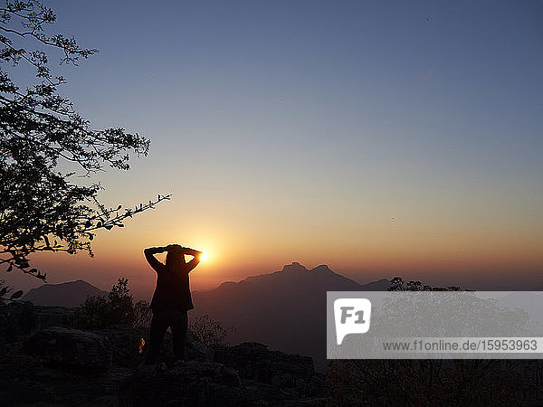 Silhouette einer Frau  die den Sonnenuntergang beobachtet  Serra da Leba  Angola