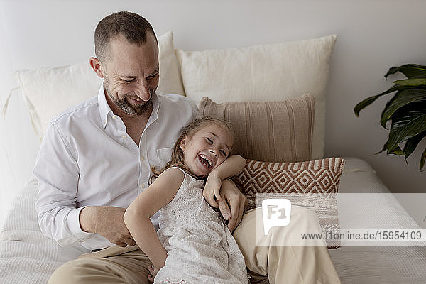 Vater kitzelt seine kleine Tochter