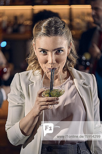 Portrait of a young woman having a cocktail in a bar