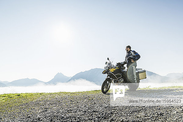 Motorcyclist on a trip having a break in the mountains  Achenkirch  Austria
