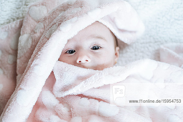 Porträt eines kleinen Mädchens mit rosa Decke