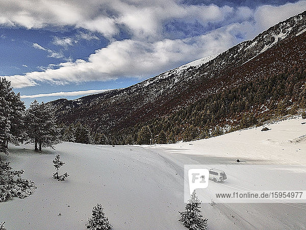 Spain  Asturias  Cornellana  4x4 car driving across snow-covered mountain valley