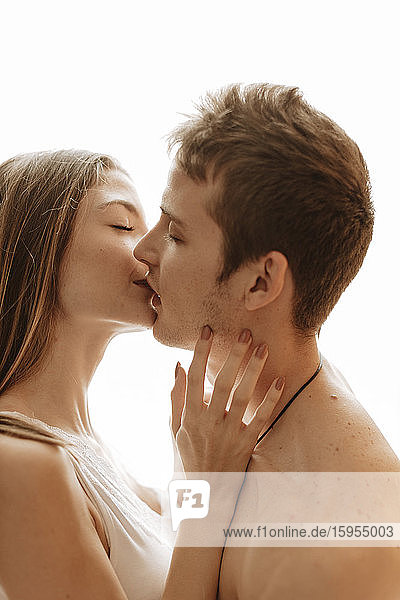 Portrait of intimate young couple kissing