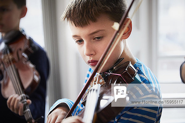 Boy playing violin during a lesson