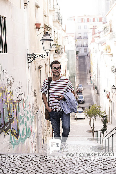 Junger Mann geht in der Stadt eine Treppe hinauf  Lissabon  Portugal