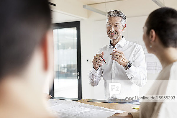Mature businessman leading a meeting in office