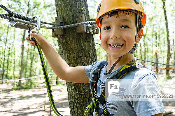 Boy on a high rope course in forest