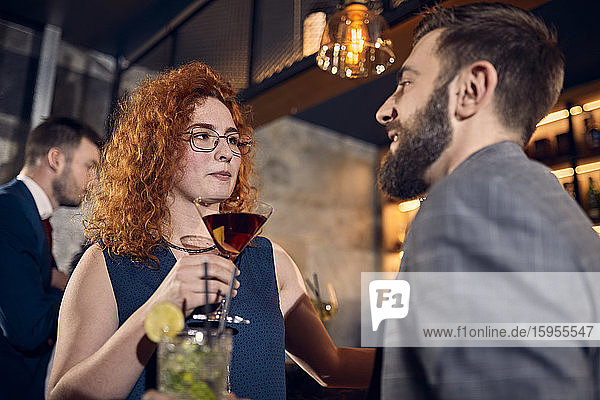 Couple with drinks talking in a bar