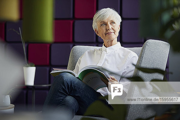 Porträt einer nachdenklichen älteren Geschäftsfrau  die auf einem Sessel sitzt