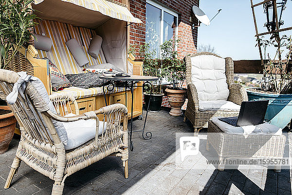Terrasse mit Gartenmöbeln und Laptop