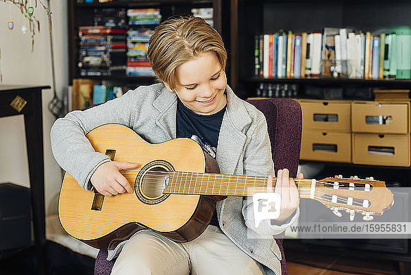 Junge spielt zu Hause Gitarre