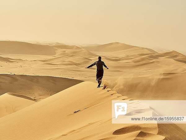 Man running on a dune in the desert  Dune 7  Walvis Bay  Namibia