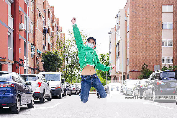 Boy wearing protective mask and jumping on a street
